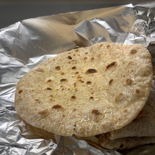 An Indian restaurant style four ingredient plain chapati topped with ghee.