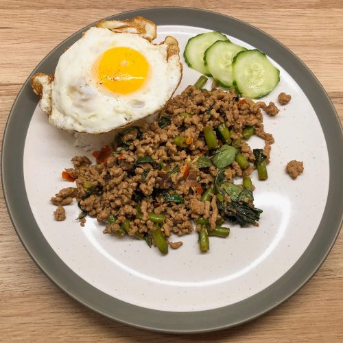 Chilli & Thai Basil Pork on a serving plate with jasmine rice and a crispy fried egg.