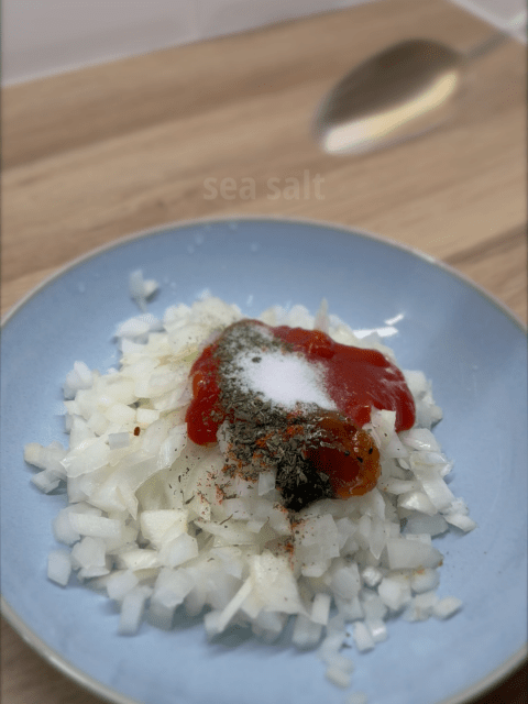 Chopped onions in a bowl topped with classic Scottish spiced onion ingredients (ketchup, mint sauce, mango chutney, spices etc).