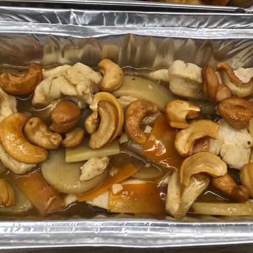 Chinese takeaway style chicken with cashew nuts in a foil container.