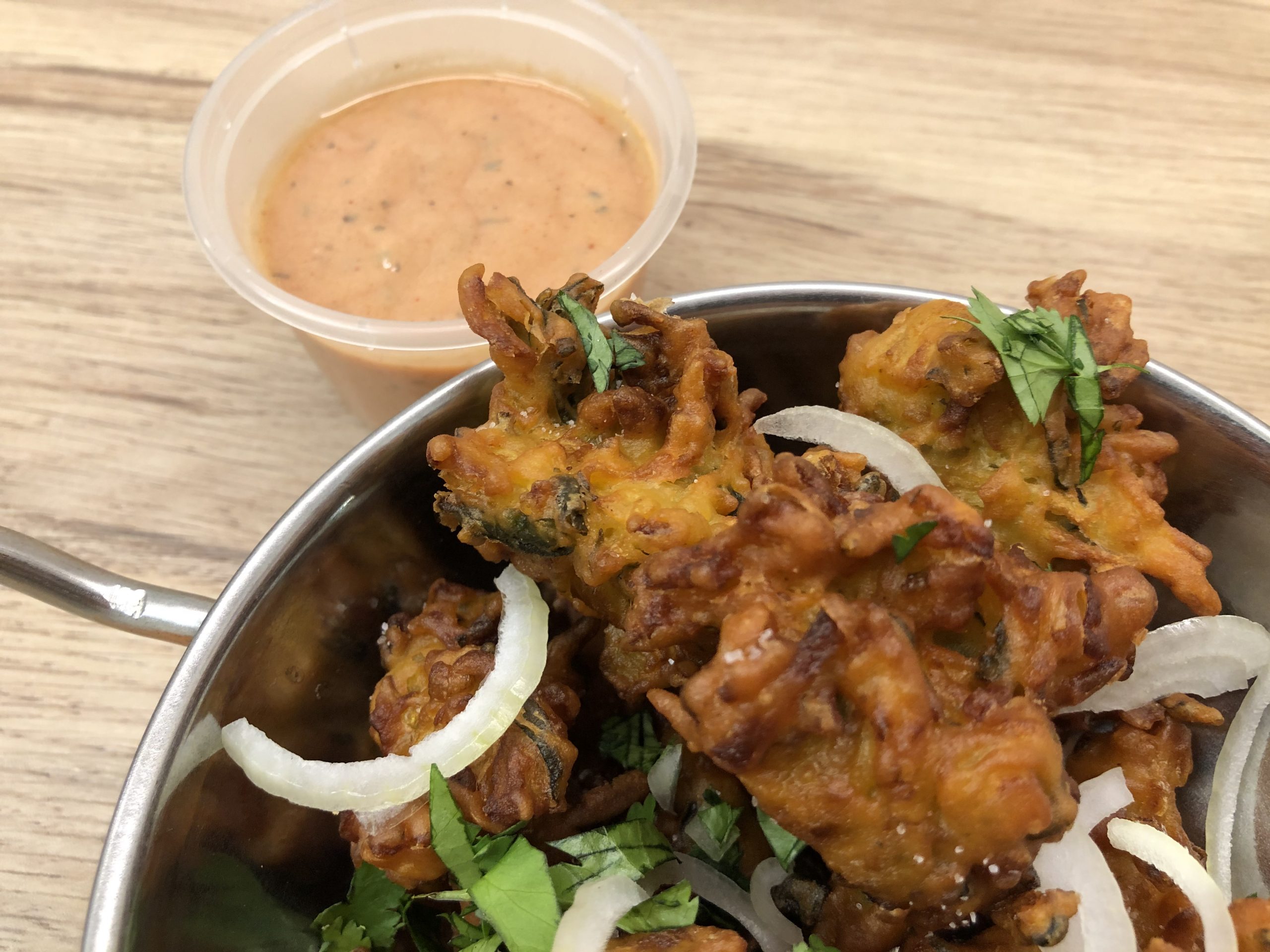 Pink pakora sauce served alongside vegetable pakora.