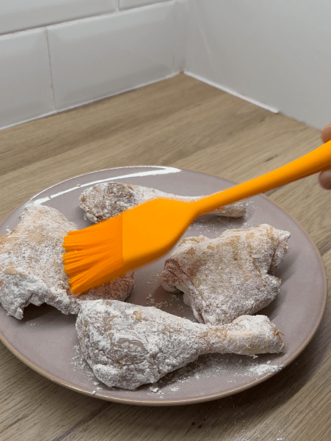 Marinated chicken pieces flour coated and brushed with oil ready to be air fried.