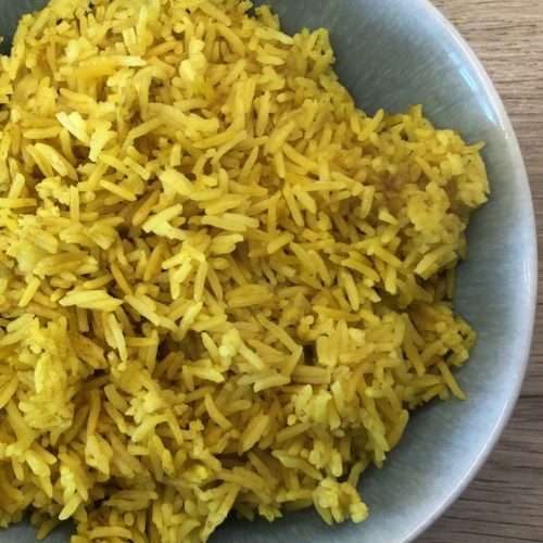 Fluffy, fragrant Indian takeaway style pilau rice in a serving bowl.