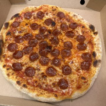 A takeaway style pepperoni & hot honey pizza in a pizza box.