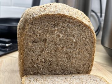 A sliced wholemeal seeded bread loaf.