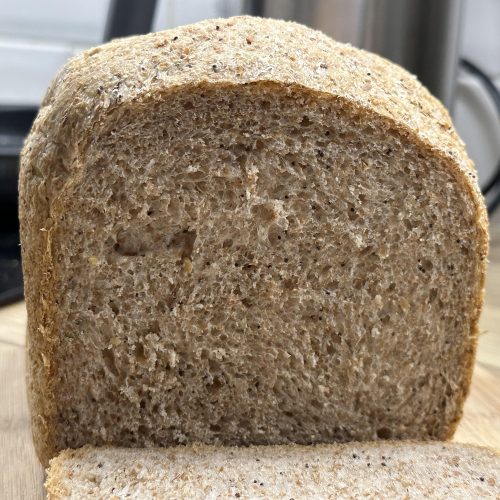 A sliced wholemeal seeded bread loaf.