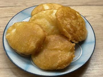 Chip shop style potato fritters on a serving plate