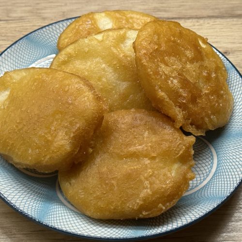 Chip shop style potato fritters on a serving plate