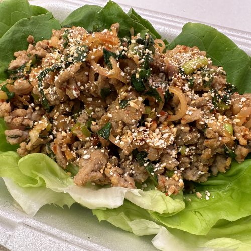 Thai style minced pork salad (laab moo) on a bed of lettuce leaves.