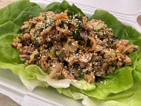 Thai style minced pork salad (laab moo) on a bed of lettuce leaves.