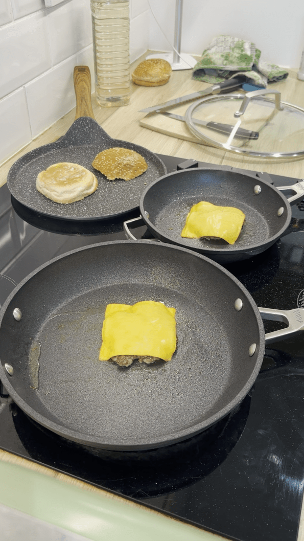 Burger patties flipped and each topped with a cheese slice.