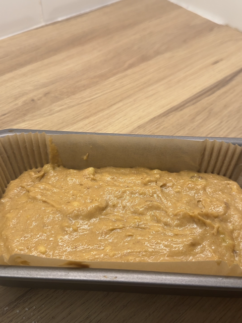 Banana Bread mix in a lined loaf tin ready to bake.