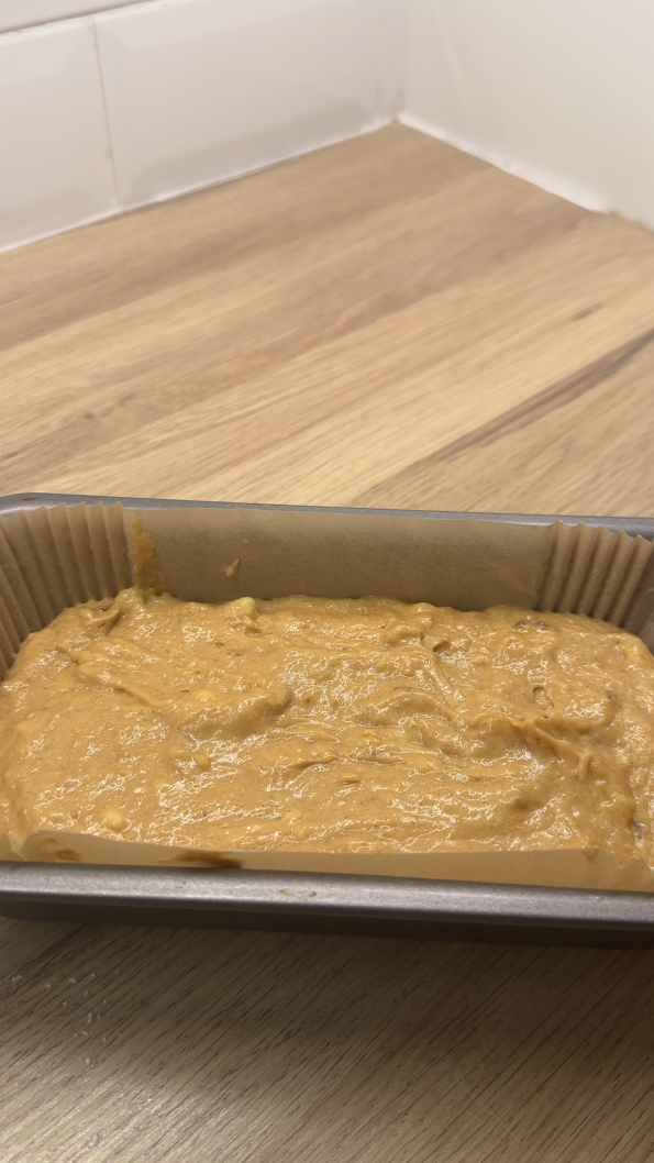 Banana Bread mix in a lined loaf tin ready to bake.